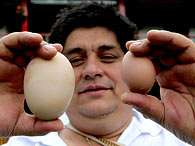 O dono da galinha, Hernando Ni�o, mostra o ovo "gigante" e outro ovo considerado normal. Foto: EFE