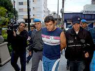 Adelson Aparecido Tomaz, conhecido como Paran�, � conduzido por policiais ap�s ser preso em S�o Jos�, SC . Foto: Helio Torchi/Futura Press