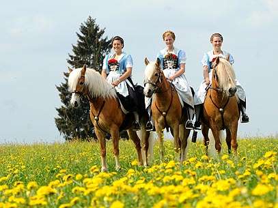 Vestindo roupas tradicionais da Baviera, jovens alemãs participam de cavalgada em homenagem a São Jorge, em Traunstein. Foto: AFP  