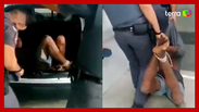 Homem negro é carregado com as mãos e os pés amarrados por PMs em SP