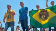 Com bandeira do Brasil com imagem do pai, Fl&aacute;vio diz que Bolsonaro lhe entregar&aacute; faixa presidencial