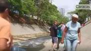 Desesperados, venezuelanos coletam água em valas de esgoto