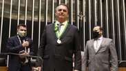 Sob protestos e aplausos, Bolsonaro recebe medalha na Câmara