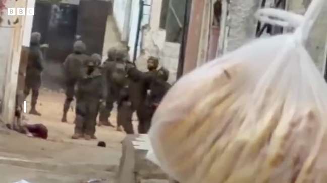 Soldado israelense coloca objeto ao lado de menino palestino