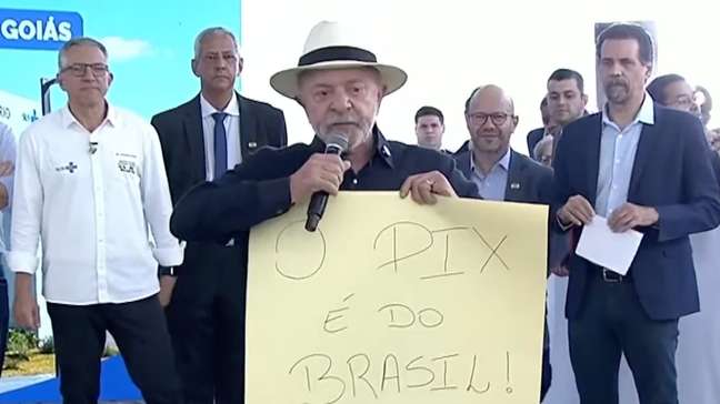Lula exibe cartaz e usa telão com mensagem em defesa do Pix após proposta de novo tarifaço dos EUA