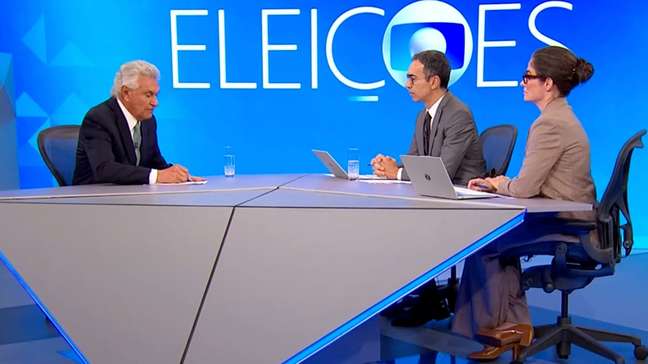 Caiado desenha em papel para explicar proposta de cortes de gastos a Tralli durante entrevista