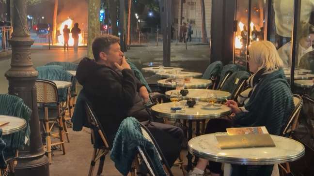 Casal é flagrado bebendo e conversando em meio a protestos em Paris