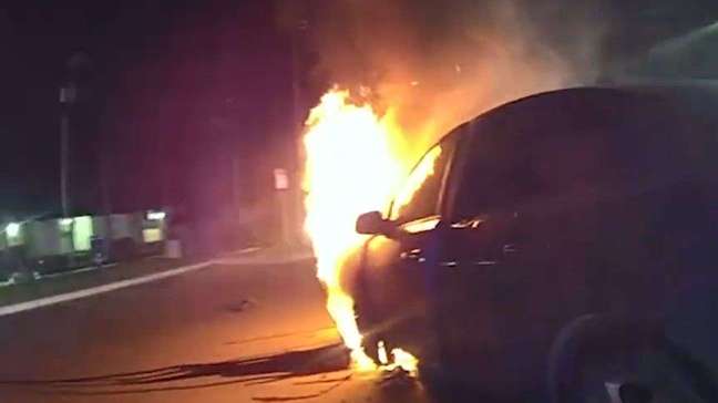 Policiais salvam mulher inconsciente de carro em chamas 